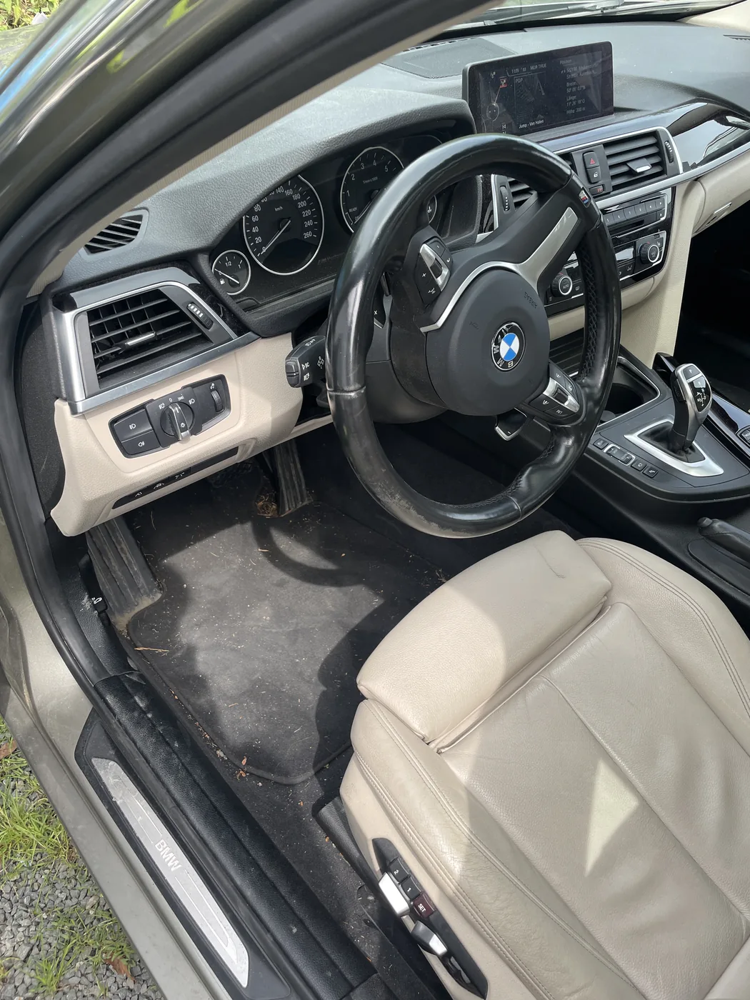 Cockpit eines BMW mit heller Lederausstattung vor der Innenraumaufbereitung