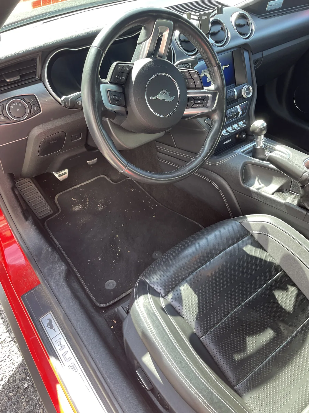 Ledersitze und Fußraum eines Ford Mustang vor der Aufbereitung